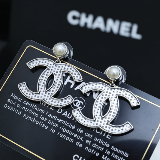 DOUBLE C EARRINGS IN SILVER METAL WITH BLACK SNOWFLAKE EMBOSSED ON WHITE ENAMEL