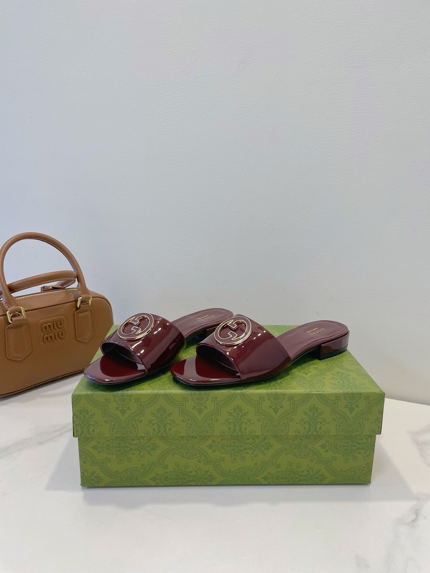 SLIDE SANDALS IN WINE RED GLOSSY SHEEPSKIN ENAMELLED ROUND INTERLOCKING G