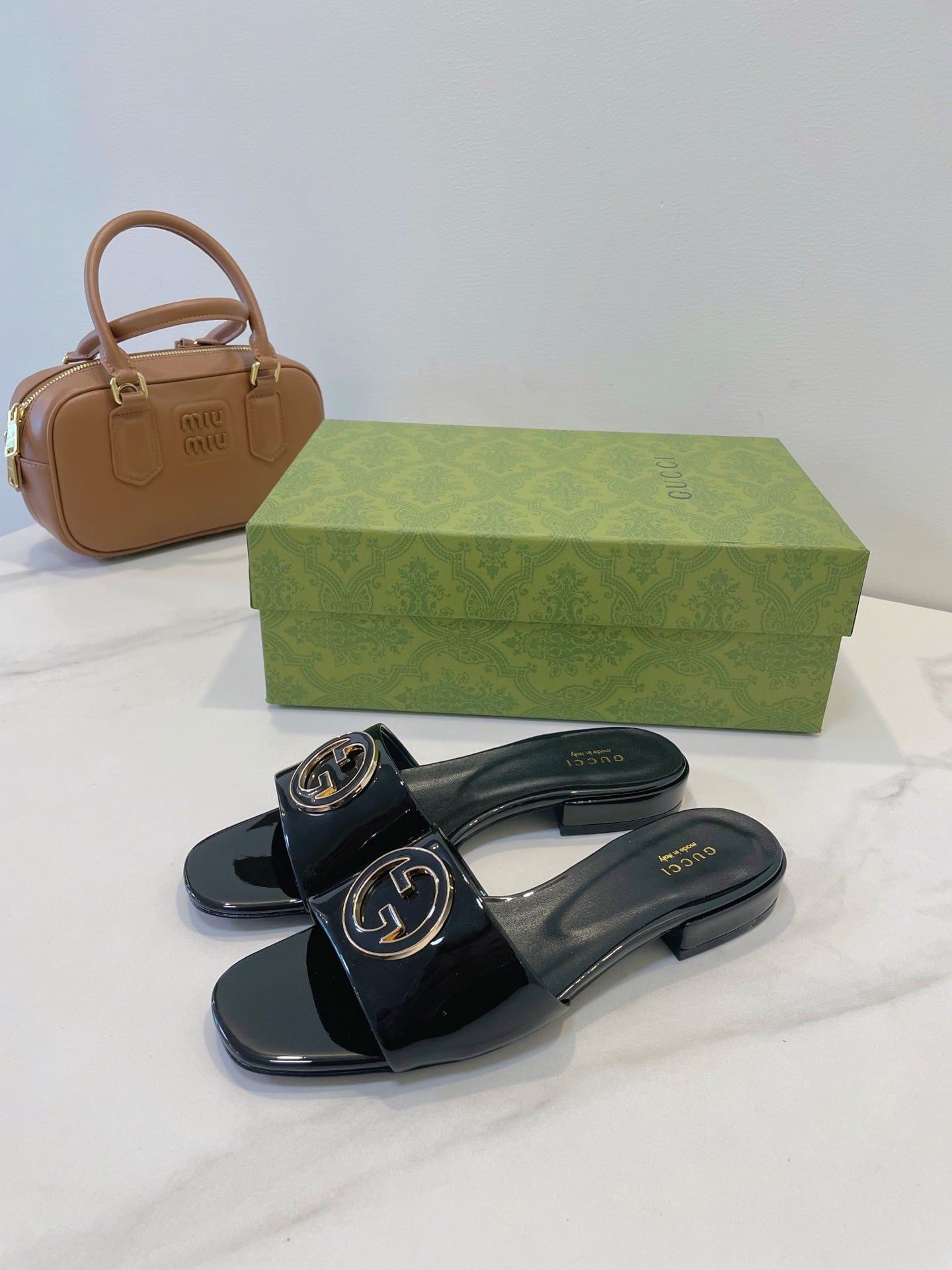 SLIDE SANDALS IN BLACK GLOSSY SHEEPSKIN ENAMELLED ROUND INTERLOCKING G